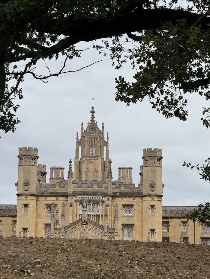 Historic architecture of St Johns College, Cambridge on an overcast day.